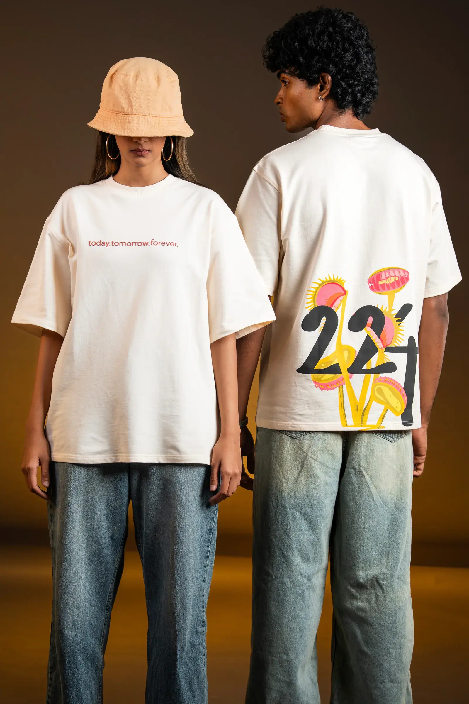 Two models in oversized white graphic tees and relaxed denim